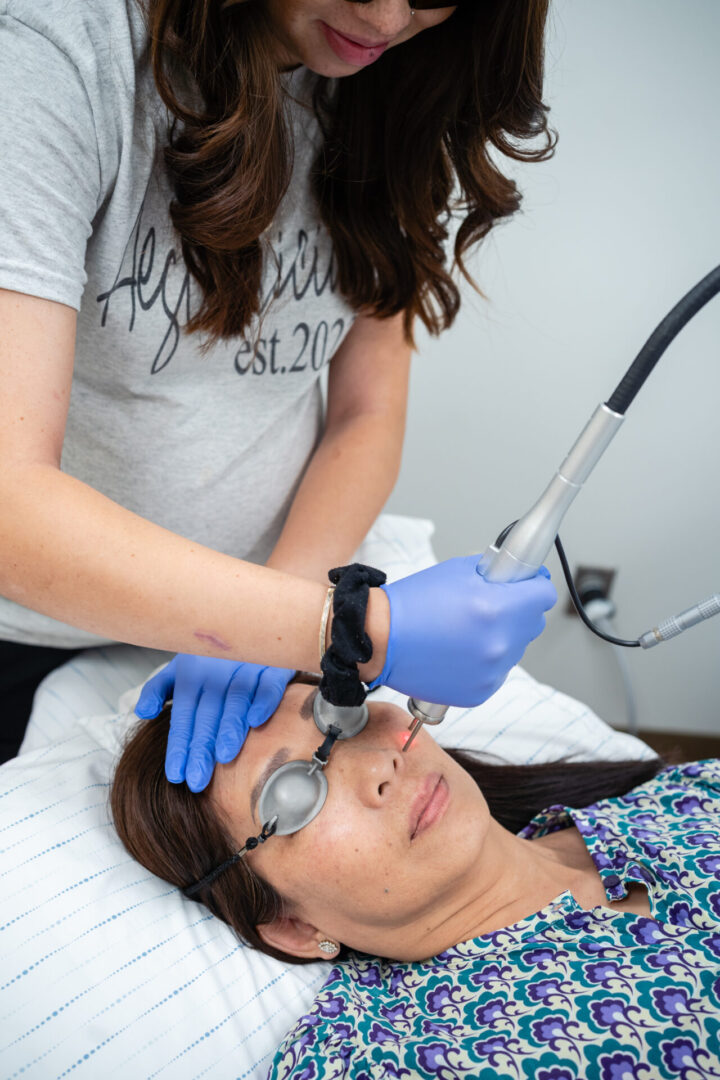 A woman getting her face cleaned by an esthetician.