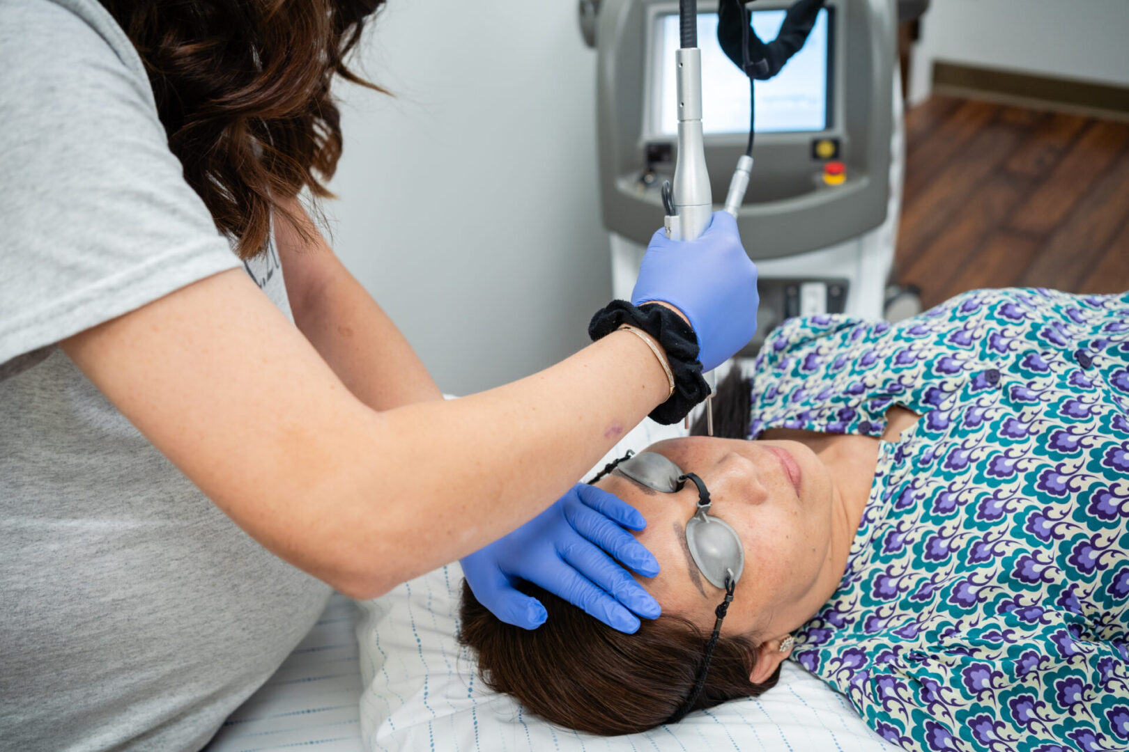 A woman is getting her face cleaned by an esthetician.