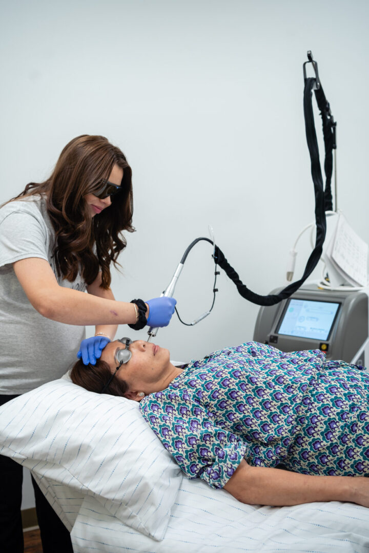 A woman is using an electric device to treat a patient.