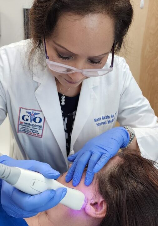 A woman in white coat getting her teeth checked.